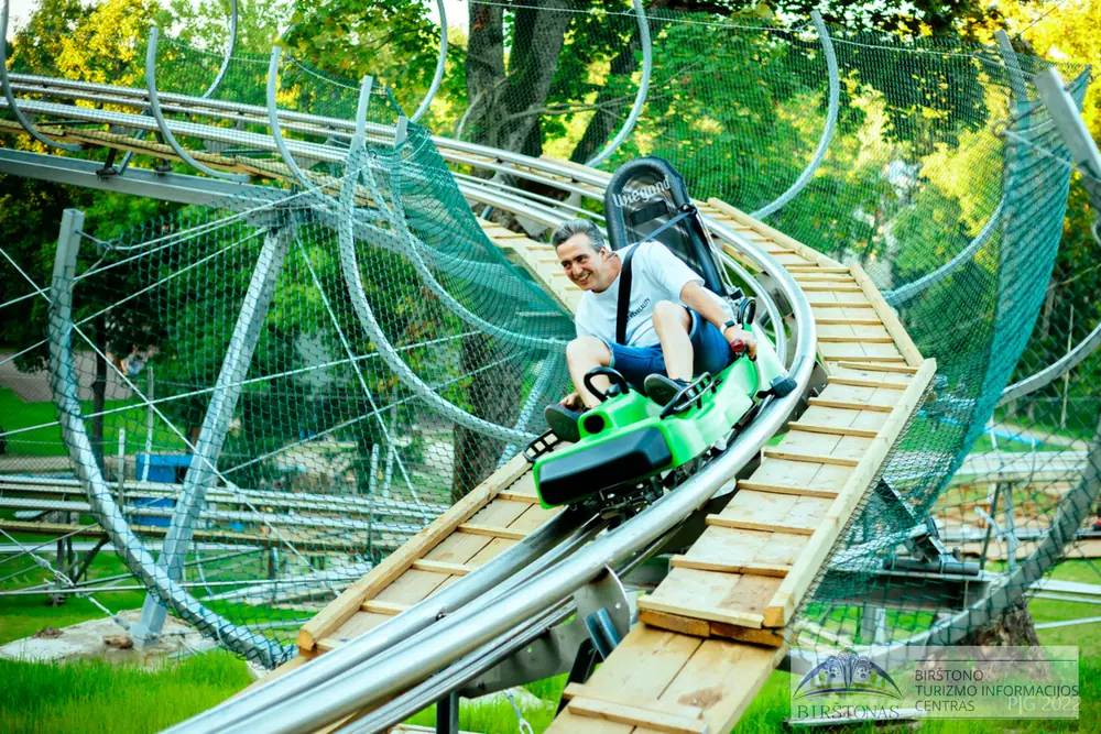 A rider passing the ring structure of the Birštonas alpine coaster