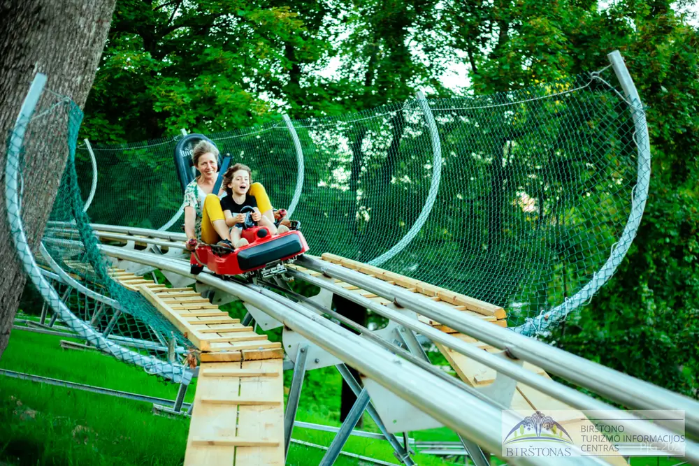 Two riders in the ring section of the Birštonas alpine coaster