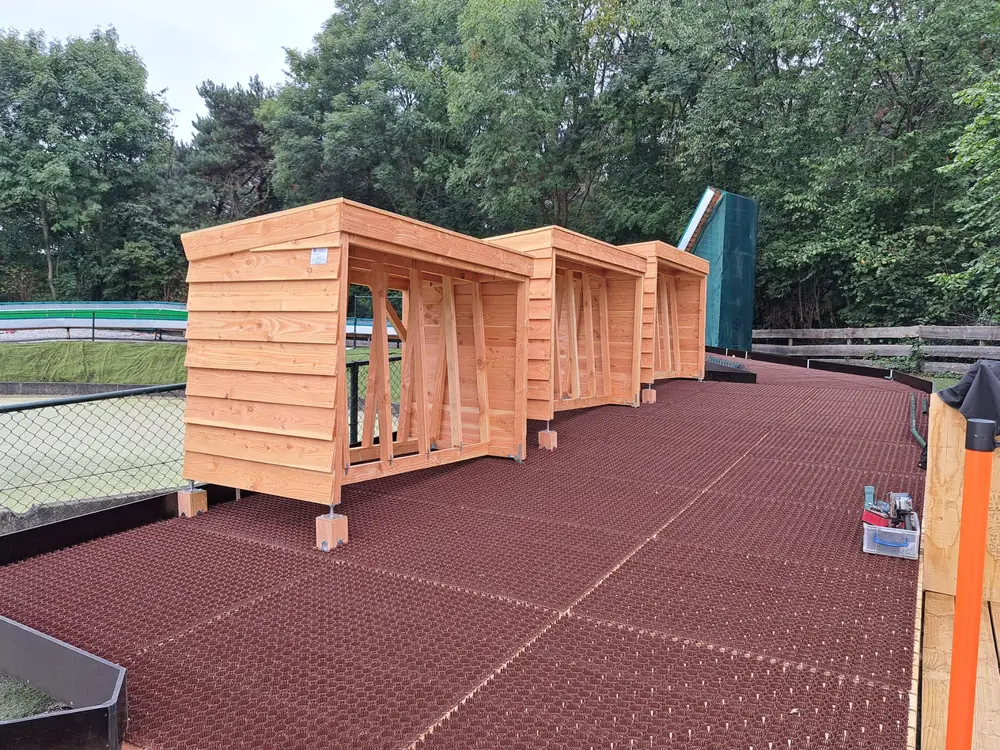 Wooden kiosks on a rubber-matted entry area next to a tubing slide