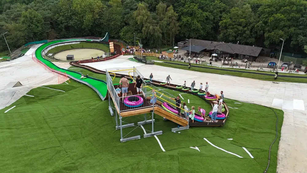 Aerial view of a tubing slide's raised starting platform with riders waiting
