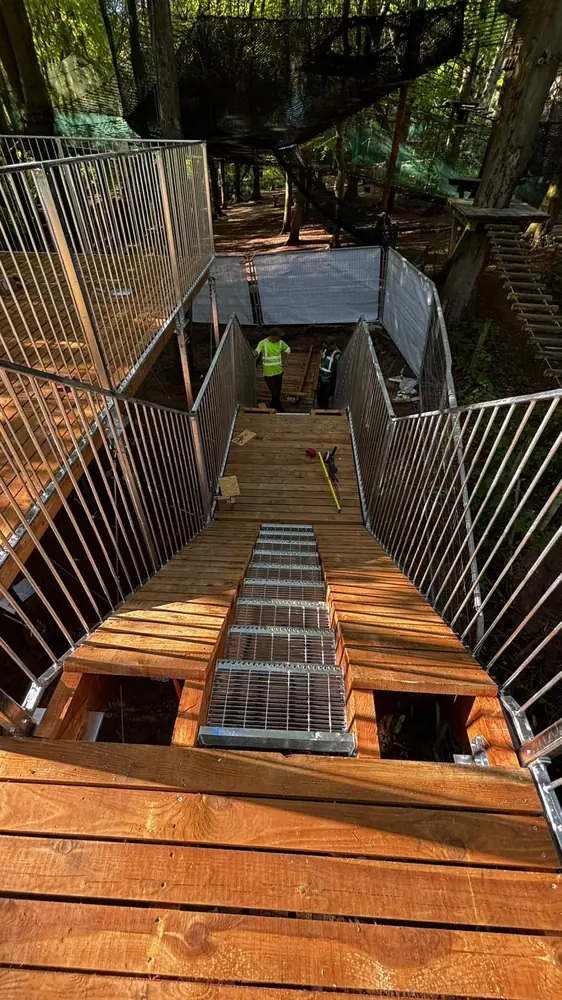 Wooden starting platform with a conveyor ramp between steel railings