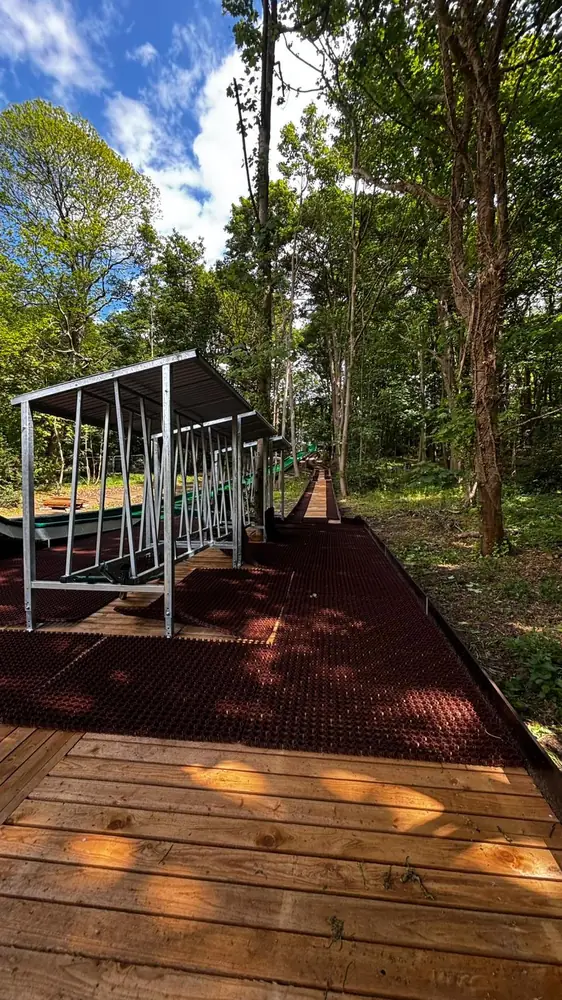 Tube storage racks along a wooden walkway in a forest