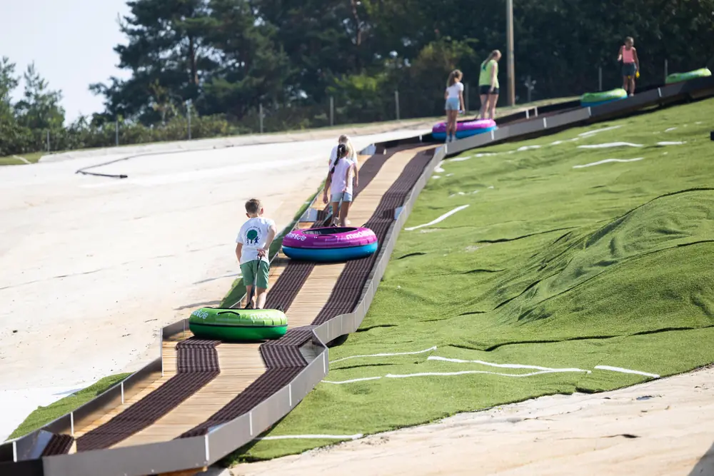A child pulling a tube up the walkway along the slope at Wijchen