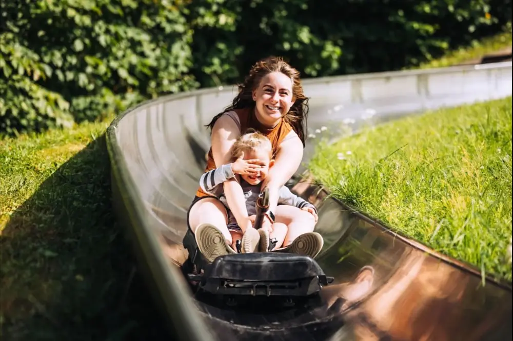 A mother and child riding the Rāmkalni toboggan run