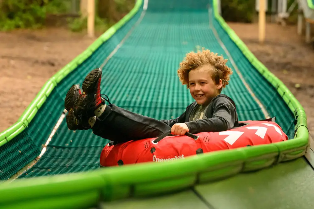 A boy in a red tube on a Modislide forest track