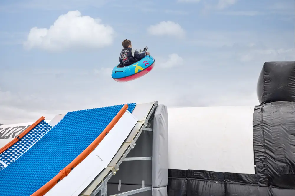 A rider launching off a Modi jump slide towards an airbag