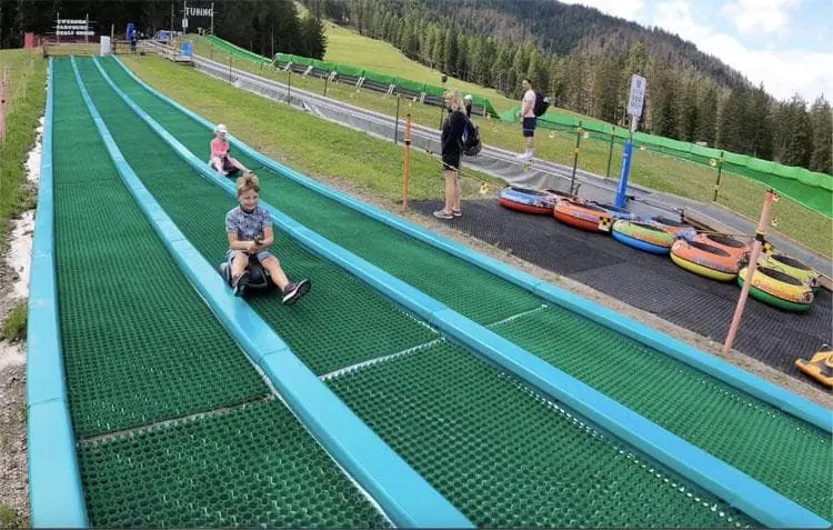 A three-lane Sklide next to a tubing area at Monte Baranci