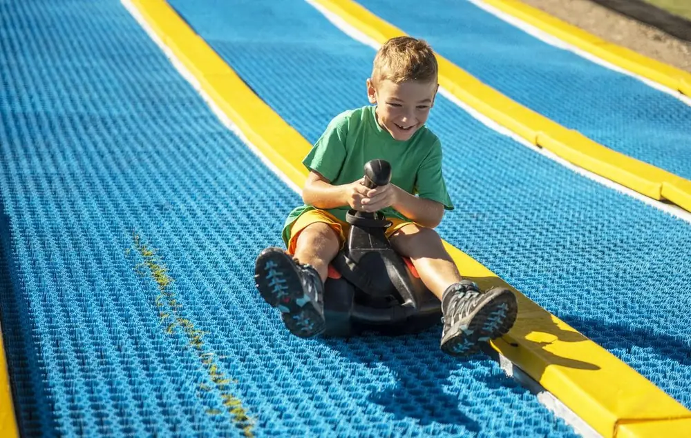 A boy steering a Sklide sled with its joystick