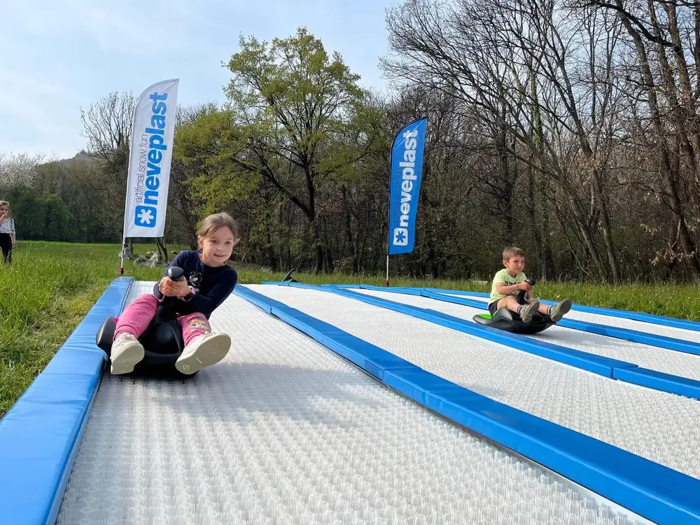 Two children racing on Sklide lanes