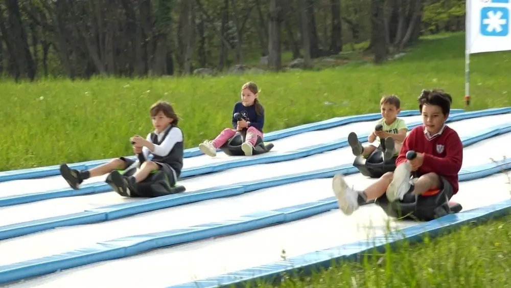 Four children racing on parallel Sklide lanes